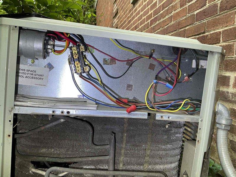 # HVAC Maintenance Service Completed

Performed comprehensive clean and check maintenance on a 29-year-old residential air conditioning system located in the backyard serving the whole house. Conducted thorough inspection of outdoor condensing unit, removing access panel to evaluate electrical components, wiring connections, and internal coil condition. Observed aging equipment with visible dust accumulation on heat exchanger coils. Verified all electrical connections, terminal blocks, capacitor, and control wiring configurations for proper operation and safety compliance. Documented equipment condition with detailed photographs showing electrical compartment layout and coil assembly. System operational at time of service with opportunities identified for future equipment upgrade considerations due to advanced age of installation.