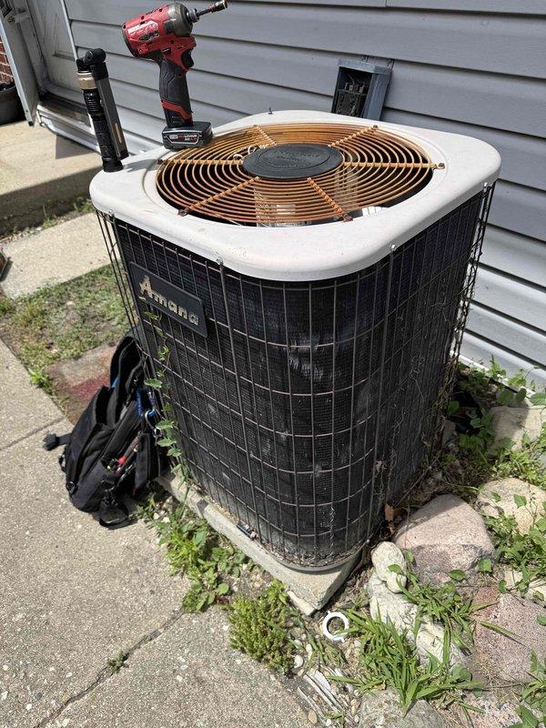 Responded to no cooling complaint on Amana air conditioning system. Upon arrival, verified thermostat settings and confirmed unit was not producing cold air. Performed visual inspection of outdoor condenser unit and indoor refrigerant line connections. Measured refrigerant line spacing and documented equipment specifications. Checked electrical connections, breaker status, and air filter condition. Conducted diagnostic assessment of condenser components including fan motor operation and coil condition. Photographed equipment nameplate data and refrigerant line configuration for service records. System evaluated and measurements taken to determine proper repair recommendations.