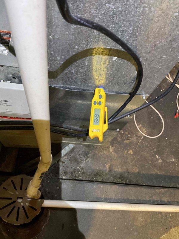 Performed comprehensive clean and check maintenance on American Standard HVAC system, including thorough inspection of air conditioning components and heat exchanger evaluation. Installed bypass recirculating component under furthest sink location and verified operational parameters of recently installed equipment. Conducted diagnostic testing with digital instruments, recording temperature readings and assessing system performance, while documenting condensate drain condition showing mineral deposit accumulation on components.