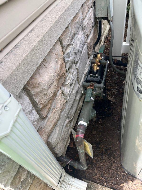Conducted equipment assessment for aging 19-year-old air conditioning system at residential property. Customer expressed interest in replacement options, specifically requesting information on Carrier, Trane, and American Standard brand equipment. Documented existing outdoor condensing unit installation, noting current configuration with side yard placement on concrete pad, electrical disconnect, refrigerant line set routing, and condensate drainage system. Photographed equipment location, surrounding clearances, and access points to facilitate accurate replacement system sizing and installation planning.