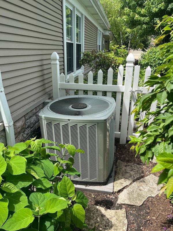 Conducted equipment assessment for aging 19-year-old air conditioning system at residential property. Customer expressed interest in replacement options, specifically requesting information on Carrier, Trane, and American Standard brand equipment. Documented existing outdoor condensing unit installation, noting current configuration with side yard placement on concrete pad, electrical disconnect, refrigerant line set routing, and condensate drainage system. Photographed equipment location, surrounding clearances, and access points to facilitate accurate replacement system sizing and installation planning.
