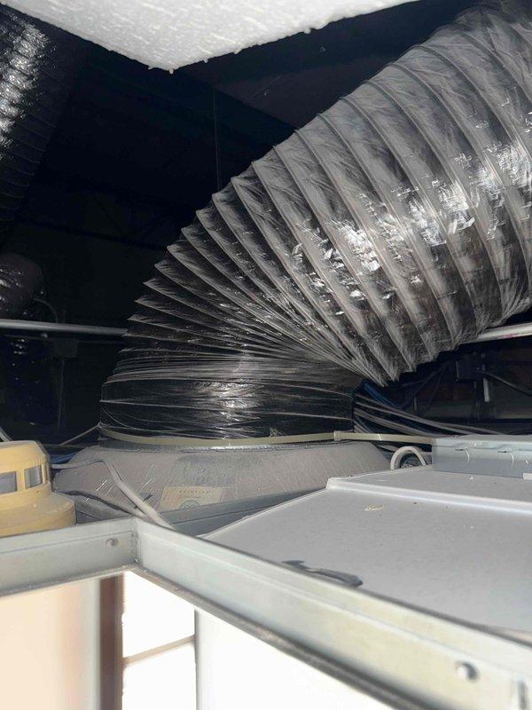 Responded to reported roof leak at commercial facility. Upon investigation following roofer's assessment indicating water entry from mechanical unit, inspected rooftop HVAC equipment and associated ductwork. Examined RTU installations on gravel ballast roof system and interior ductwork connections for signs of water intrusion or condensate drainage issues that could be causing leak into tenant space.