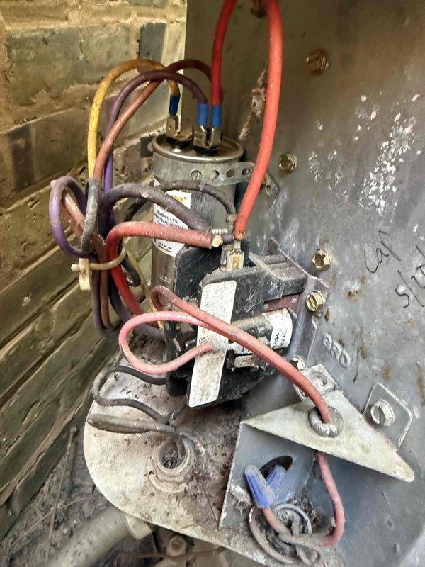 Responded to service call for air conditioning unit producing loud rattling noise during startup. Upon arrival, performed diagnostic inspection of outdoor condensing unit and electrical components. Measured electrical current draw using clamp meter, which showed readings within normal operating range at 0.93 amps. Conducted thorough visual and auditory inspection of compressor, fan motor, mounting hardware, and capacitor assembly. Inspected all electrical connections, wire terminals, and capacitor for signs of loose components or deterioration. Unit was operational and providing adequate cooling at time of inspection. Documented equipment condition with photos showing electrical measurements and component assembly. Noise concern noted but unit functioning properly during diagnostic period.