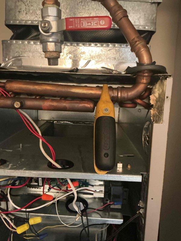 Responded to callback for AC system not cooling below 86 degrees following previous service visit. Performed diagnostic inspection of HVAC equipment in mechanical room, examining condensate drainage system, ductwork integrity, and internal cabinet components. Inspected copper refrigerant lines showing oxidation and corrosion, verified ball valve operation, and assessed heat exchanger condition with visible staining. Conducted electrical system evaluation including wire connections and terminations. Used diagnostic measurement equipment to test system performance parameters and identify root cause of insufficient cooling capacity.