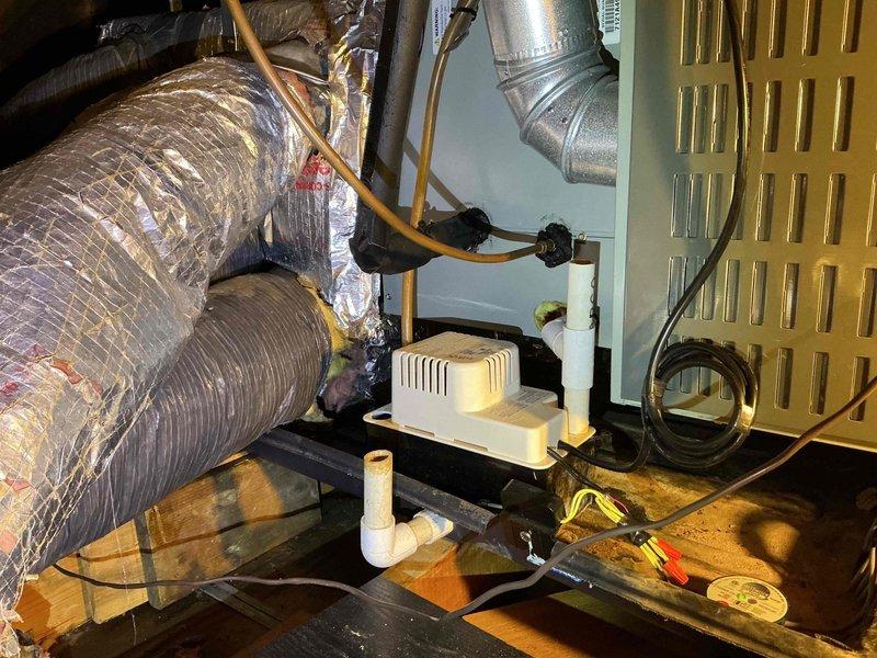 Responded to emergency callback for first floor A/C system with reported water damage to interior ceiling. Upon arrival, found electrical disconnect box improperly mounted to exterior wall with loose wiring connections creating unsafe operating conditions. Remounted disconnect enclosure and re-terminated all line and load connections to restore temporary functionality. Observed condensate drainage system in attic space and verified condensate pump operation. Due to inherent structural deficiencies in disconnect box mounting system, current repair is temporary solution only—wiring will likely become displaced during future service access. Provided estimate for permanent disconnect replacement to ensure safe, code-compliant installation. Coordinated with management regarding water intrusion concerns and previous service history on this unit.