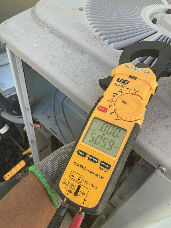 Responded to no cooling complaint on 6-9 year old residential air conditioning system that ceased maintaining temperature below 78 degrees after initial operation in newly purchased home. Performed diagnostic evaluation of outdoor condensing unit, utilizing digital clamp meter to measure electrical current draw and verify compressor operation. Inspected blower wheel assembly and internal components for proper airflow and mechanical function. Documented equipment condition showing accumulated dirt and environmental exposure on exterior surfaces requiring attention. Provided assessment and recommendations for restoring proper cooling capacity to system.