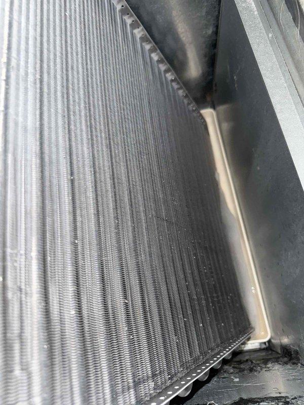 Responded to no cooling complaint with reported strange noise and water leakage. Found severely restricted airflow due to extremely dirty air filter causing evaporator coil to freeze and resulting in active condensate overflow. Documented condition of outdoor condenser coil showing significant dirt accumulation on fin surfaces. Performed electrical diagnostics on blower motor and system components using digital multimeter to verify proper operation. System required filter replacement and coil thawing before normal operation could resume.