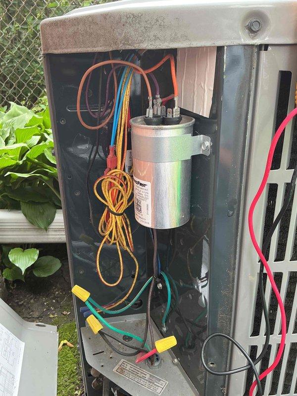 # HVAC Maintenance - Comfort Plan Clean and Check 1 System

Performed comprehensive spring clean and check maintenance on single air conditioning system per service contract plan. Completed full system inspection including outdoor condensing unit and indoor air handling components.

## Outdoor Unit Service

Removed and secured access panels on outdoor condensing unit for thorough inspection. Examined electrical components including dual capacitor with proper wire connections - verified orange, yellow, blue, pink, and green wiring terminals secure and properly terminated. Inspected wire bundling and connections throughout electrical compartment, noting all connections tight and functioning within specifications. Checked capacitor mounting and hardware security.

Cleaned condenser coil fins and exterior surfaces, removing accumulated dirt, debris, and vegetation buildup from unit perimeter. Verified proper airflow clearance around unit positioned near fence line. Inspected cabinet condit