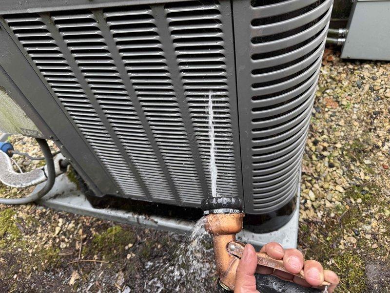 Completed comprehensive clean and check maintenance service on two air conditioning systems per comfort plan agreement. Performed standard preventive maintenance procedures including inspection of electrical components, capacitors, and control boards on both units. Addressed active refrigerant leak at copper service port connection on outdoor unit, with water spray visible during service indicating need for potential system repair or component replacement. Documented equipment conditions through photos of outdoor condenser unit and interior electrical compartment showing control board, capacitor, and wiring connections. Customer expressed interest in early comfort plan renewal.