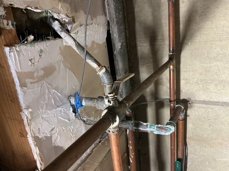 Responded to commercial boiler leak at piping end cap. Coordinated with facility personnel to identify which isolation valves were closed prior to repair work. Assessed damaged piping configuration and determined appropriate copper press cap sizing, utilizing ¾" and ½" fittings as needed. Successfully repaired leak at end cap connection point on boiler piping system. Documented existing plumbing infrastructure including copper and galvanized pipe runs with mounting brackets. Isolation valves will require reopening upon completion of repair work to restore full system operation.
