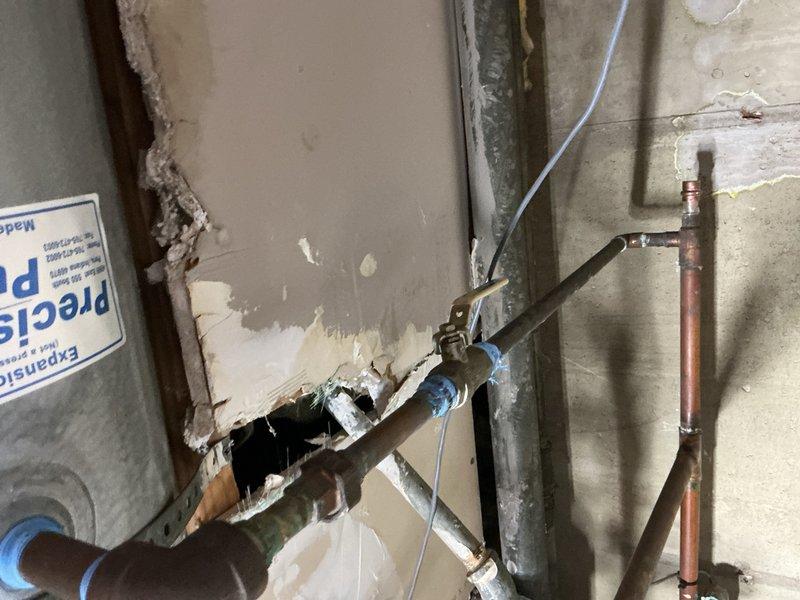 Responded to commercial boiler leak at piping end cap. Coordinated with facility personnel to identify which isolation valves were closed prior to repair work. Assessed damaged piping configuration and determined appropriate copper press cap sizing, utilizing ¾" and ½" fittings as needed. Successfully repaired leak at end cap connection point on boiler piping system. Documented existing plumbing infrastructure including copper and galvanized pipe runs with mounting brackets. Isolation valves will require reopening upon completion of repair work to restore full system operation.