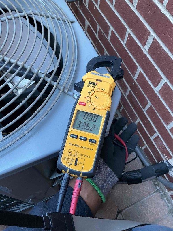 Completed comprehensive clean and check maintenance service on single air conditioning system as part of comfort plan agreement. Performed electrical diagnostics using clamp meter to verify system amperage and voltage readings, confirming unit operating within manufacturer specifications at 336.2V and 50.12 readings respectively. Collected payment for comfort plan renewal and documented system condition with photos showing outdoor condenser unit and electrical measurements.
