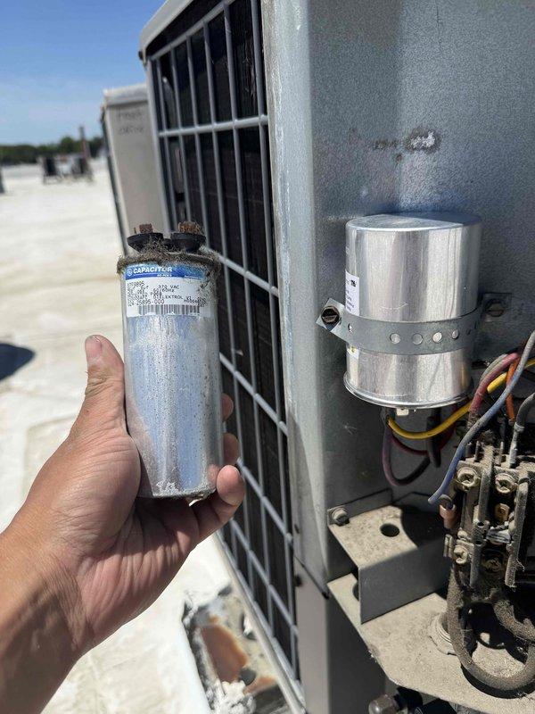 Returned to commercial rooftop unit to complete previously diagnosed repair. Replaced failed 45/5 dual run capacitor on HVAC system. Removed weathered capacitor showing signs of corrosion and installed new replacement unit. Secured capacitor with mounting bracket and reconnected all electrical terminals. Verified system operation and confirmed thermostat responding properly with unit cycling correctly. Collected final payment for completed repair work.