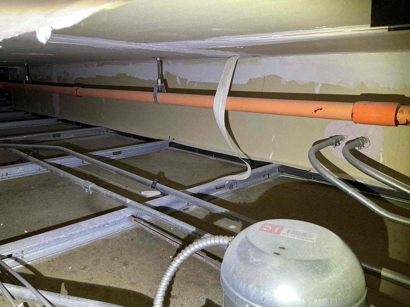 Responded to service call to inspect reported ceiling crack located below rooftop RTU. Accessed rooftop unit and performed thorough visual inspection of unit base, drain pan, condensate lines, and surrounding roofing membrane to identify potential water intrusion sources. Inspected interior ceiling space below unit, examining structural framing, conduit routing, and ceiling surface for moisture damage or active leaks. Confirmed RTU is not leaking, drain system is functioning properly, and roofing material around unit curb remains intact with no visible penetrations or deterioration. Documented findings with photos of unit interior components and ceiling cavity conditions. Contacted property contact to report that ceiling crack is not related to HVAC equipment malfunction or water discharge from the rooftop unit.