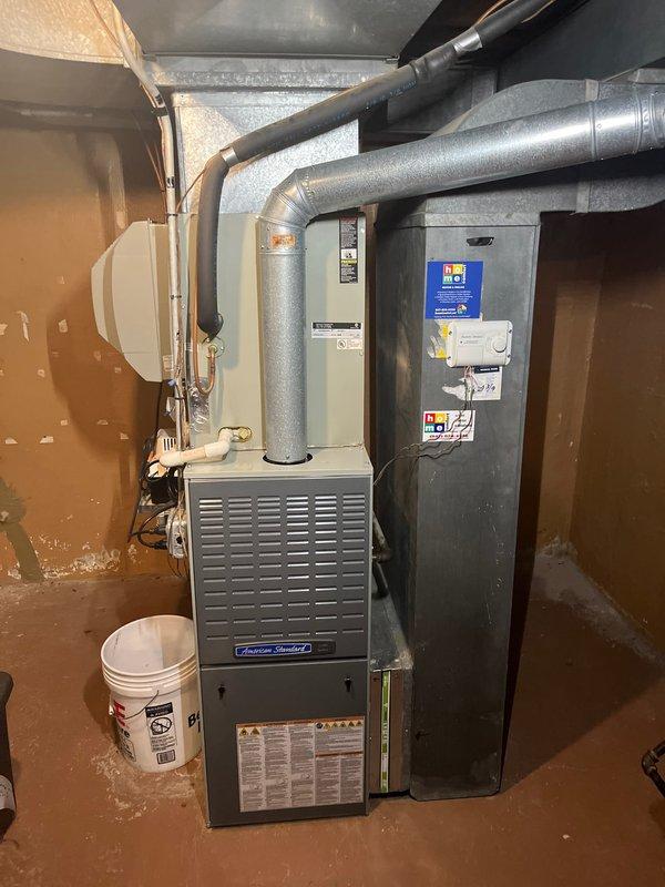 Conducted in-home assessment for HVAC system replacement on aging equipment including a 30-year-old air conditioning unit and 13-year-old furnace with identified crack formation. Documented existing American Standard furnace installation in basement mechanical room and evaluated exterior AC unit located in backyard, both systems having reached end of serviceable life. Provided comprehensive replacement estimate for complete whole-house heating and cooling system upgrade.