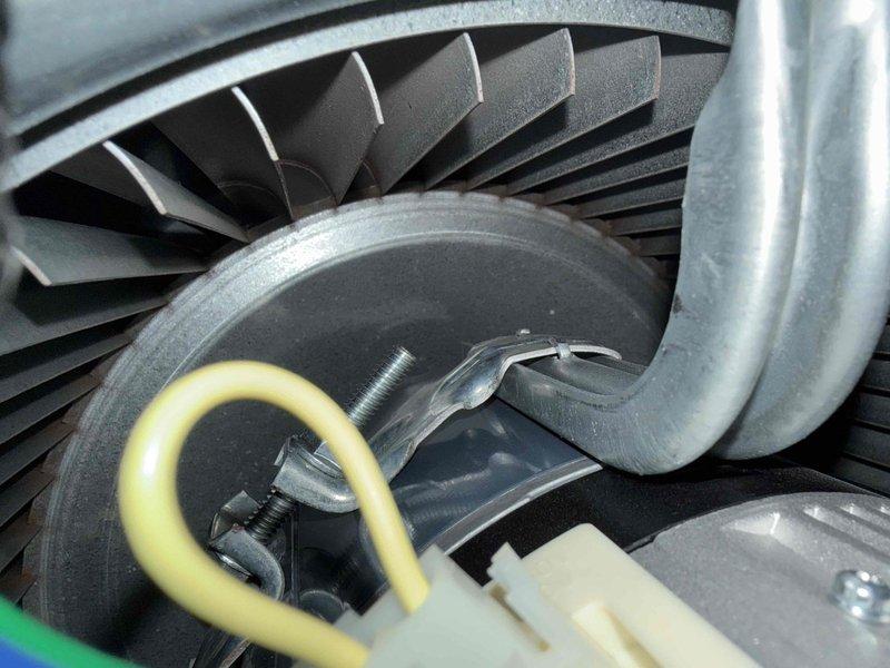 Responded to customer complaint of vibrations in living room when furnace operates. Inspected furnace system installed in 2024, focusing on blower motor assembly and inducer motor components. Examined motor mounting, fan blade assembly, and electrical connections for secure installation and proper balance. Photographed blower motor housing with cooling fins, wiring connections, and fan blade assembly to document current condition. All components appeared properly secured with no visible signs of damage or wear. Verified motor mounting bolts and hardware for tightness and proper torque specifications to eliminate potential vibration sources.
