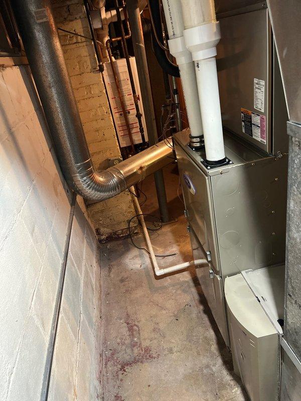 Conducted on-site evaluation for furnace replacement estimate. Existing unit, originally installed 12 years ago, has been non-operational since installation. Documented current equipment configuration including furnace, ductwork connections, and associated mechanical components in basement installation. Assessed clearances, venting system with PVC exhaust, flexible aluminum supply ductwork, and overall system layout to provide comprehensive replacement recommendations.