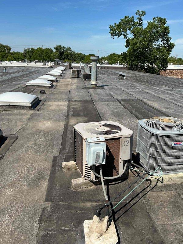 Performed commercial preventive maintenance inspection on rooftop HVAC units and basement air handler. Documented all equipment locations and model information for system records update. Inspected rooftop condensing units, verified operational status, and photographed equipment configuration including multiple AC condensers and ventilation components across flat membrane roof. Examined basement air handler unit, assessed filter compartment accessibility, and documented current filter specifications. Updated equipment inventory records and flagged discrepancies in maintenance database for filter list corrections to ensure proper ongoing service scheduling.