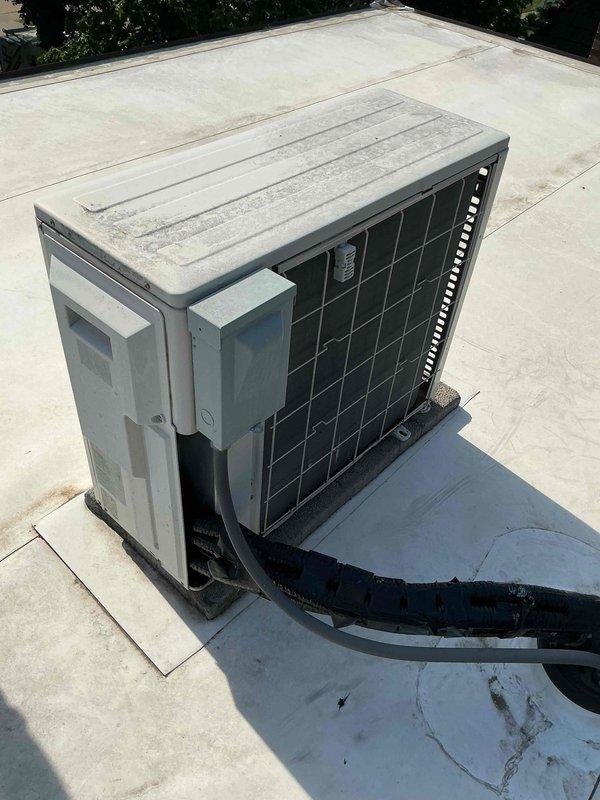 Completed Comfort Plan clean and check maintenance on two systems: one standard air conditioning unit and one mini-split system with two indoor heads. Performed comprehensive inspection and cleaning of outdoor condenser unit located on flat rooftop, including coil cleaning, electrical connection verification, and refrigerant line inspection. Serviced mini-split system requiring two-technician team with ladder access for elevated indoor air handlers. Verified system operation with temperature readings confirming proper cooling performance at 54.9°F supply air temperature. Collected payment for Comfort Plan renewal as requested.