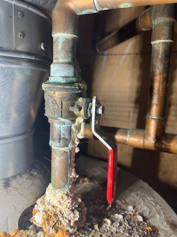 Conducted on-site assessment for replacement of two 50-gallon standard water heaters. Inspected existing units and associated plumbing infrastructure, noting significant age-related deterioration including heavy mineral deposits, corrosion, and patina buildup on copper piping and brass valves. Documented condition of shut-off valves, pipe connections, and surrounding mechanical space constraints. Photographed installation area showing compromised valve components with calcification at base connections and oxidized copper distribution lines. Evaluated confined utility space accessibility, existing venting configuration, and floor conditions for new equipment installation planning. Prepared comprehensive replacement estimate accounting for removal of obsolete units and installation of new water heating systems.
