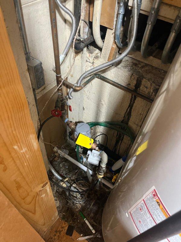 Conducted on-site assessment for replacement of two 50-gallon standard water heaters. Inspected existing units and associated plumbing infrastructure, noting significant age-related deterioration including heavy mineral deposits, corrosion, and patina buildup on copper piping and brass valves. Documented condition of shut-off valves, pipe connections, and surrounding mechanical space constraints. Photographed installation area showing compromised valve components with calcification at base connections and oxidized copper distribution lines. Evaluated confined utility space accessibility, existing venting configuration, and floor conditions for new equipment installation planning. Prepared comprehensive replacement estimate accounting for removal of obsolete units and installation of new water heating systems.