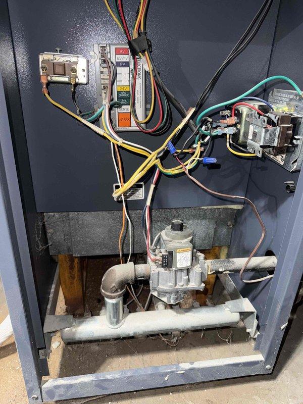 # HVAC Tune-Up Completed

Performed comprehensive preventive maintenance tune-up on residential gas furnace system. Conducted thorough inspection of all internal components including electrical controls, relays, contactors, control board, gas valve assembly, and burner system. Verified proper operation of all electrical connections and safety controls. Inspected gas manifold, piping, and valve for proper function and secure connections. Documented system condition with interior cabinet photographs showing older unit in operational status with typical age-related wear. System tested and confirmed operational upon completion of maintenance service.
