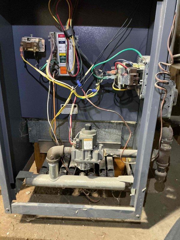 # HVAC Tune-Up Completed

Performed comprehensive preventive maintenance tune-up on residential gas furnace system. Conducted thorough inspection of all internal components including electrical controls, relays, contactors, control board, gas valve assembly, and burner system. Verified proper operation of all electrical connections and safety controls. Inspected gas manifold, piping, and valve for proper function and secure connections. Documented system condition with interior cabinet photographs showing older unit in operational status with typical age-related wear. System tested and confirmed operational upon completion of maintenance service.