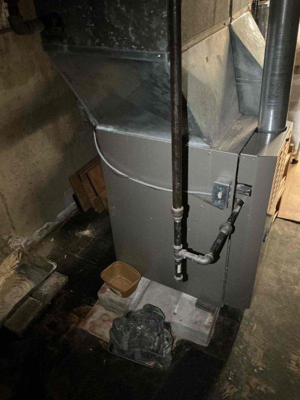 Responded to no cooling complaint on residential split system air conditioning unit, approximately 17 years old. Customer reported outdoor condenser fan motor not rotating. Performed diagnostic evaluation of outdoor unit, inspecting electrical connections, capacitor, and fan motor assembly. Verified indoor furnace and air handler operation in basement location. Documented equipment age and condition with system measurements and photographs of both indoor and outdoor components. Presented repair options and replacement recommendations due to age of system exceeding typical service life expectancy.
