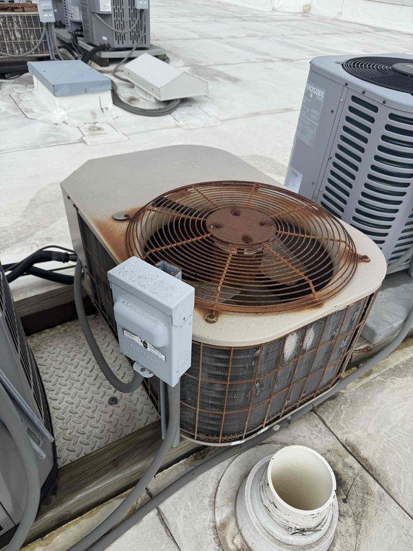 Responded to service call for thermostat malfunction at residential condo unit. Upon arrival, performed diagnostic assessment of HVAC system to identify root cause of thermostat issues. Inspection revealed the problem extended beyond the thermostat itself to the rooftop HVAC equipment, specifically affecting the air conditioning condenser unit. 

Accessed rooftop mechanical equipment and found weathered cylindrical condenser unit with visible signs of age and operational wear. Conducted electrical component testing and identified failed capacitor as primary cause of system malfunction affecting thermostat operation. Removed defective capacitor from blower motor assembly and replaced with new OEM-specification capacitor, ensuring proper electrical connections and secure mounting. Verified all wire connections, including color-coded wiring harness with appropriate wire nuts, and confirmed relay components were functioning correctly. 

Tested system operation following capacitor replaceme