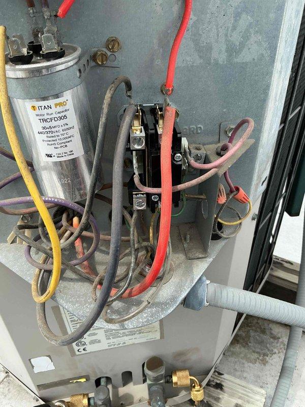 Completed Comfort Plan clean and check service on rooftop HVAC system. Performed comprehensive inspection of condenser unit, verified electrical connections at disconnect box, and inspected internal components including TITAN PRO capacitor and contactor assembly. All components found operating within normal parameters, connections secure, and system functioning properly.