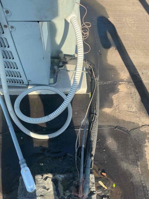 Responded to no cooling call at a converted 2-flat with rooftop HVAC unit accessed through interior roof opening. Upon arrival, found thermostat displaying 78°F set point with 45°F actual temperature reading and open battery compartment with depleted batteries. Inspected rooftop condensing unit showing signs of age with weathered components and multiple electrical connections. Identified low battery condition preventing proper thermostat operation and communication with cooling system. Replaced batteries in thermostat to restore power and proper function. Verified thermostat display operational and system able to call for cooling. Unit restored to normal operation with proper temperature control capability.