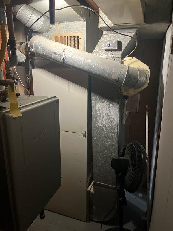 Conducted comprehensive assessment of existing residential HVAC system for equipment replacement estimate. Evaluated 20+ year old central air conditioning and heating system located in basement utility area, including furnace unit, air handler, ductwork configuration, and electrical connections. Documented current equipment condition, noting dust accumulation on metal ductwork, existing rigid and flexible duct connections, and overall system layout. Photographed furnace installation, electrical panel placement, copper refrigerant lines, distribution ductwork, and mechanical space configuration to provide accurate replacement specifications and equipment sizing recommendations for new central heating and cooling system installation.