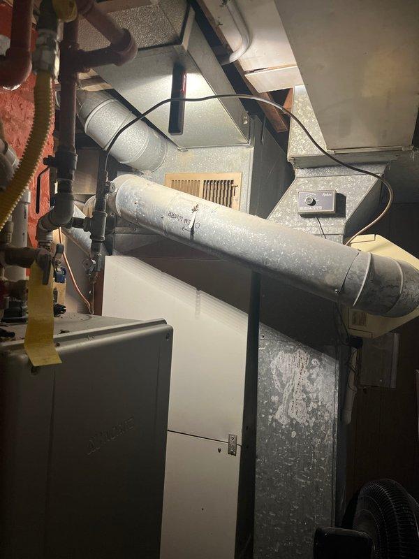 Conducted comprehensive assessment of existing residential HVAC system for equipment replacement estimate. Evaluated 20+ year old central air conditioning and heating system located in basement utility area, including furnace unit, air handler, ductwork configuration, and electrical connections. Documented current equipment condition, noting dust accumulation on metal ductwork, existing rigid and flexible duct connections, and overall system layout. Photographed furnace installation, electrical panel placement, copper refrigerant lines, distribution ductwork, and mechanical space configuration to provide accurate replacement specifications and equipment sizing recommendations for new central heating and cooling system installation.