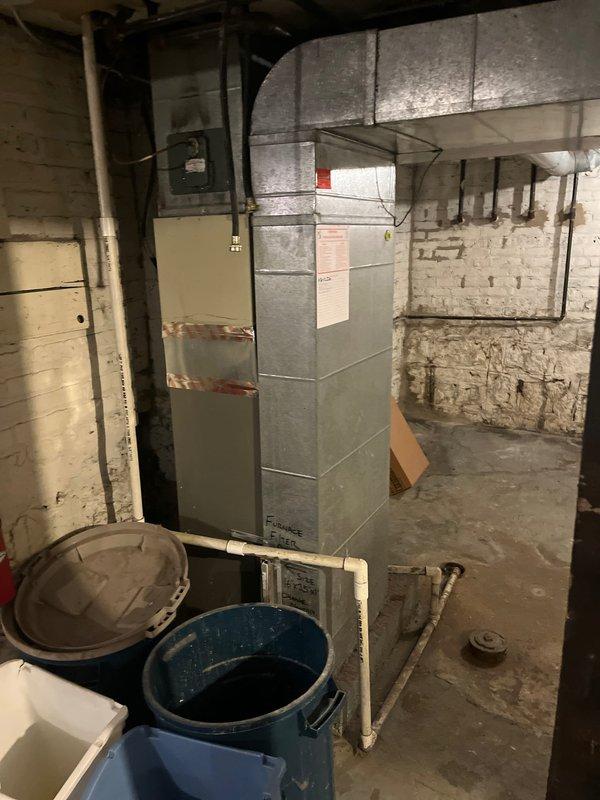 Responded to callback for continuing cooling issue where system fails to reach setpoint temperature despite thermostat being set to 60°F while indoor temperature remains at 74°F. Evaluated existing furnace and AC system in basement mechanical room to determine equipment condition and performance deficiencies. Documented current installation with caution tape marking on aged HVAC unit, assessed ductwork connections, and prepared comprehensive replacement estimate for new heating and cooling equipment to resolve persistent temperature control problems.