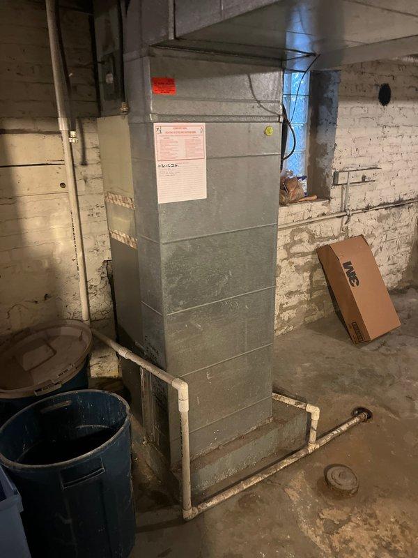 Responded to callback for continuing cooling issue where system fails to reach setpoint temperature despite thermostat being set to 60°F while indoor temperature remains at 74°F. Evaluated existing furnace and AC system in basement mechanical room to determine equipment condition and performance deficiencies. Documented current installation with caution tape marking on aged HVAC unit, assessed ductwork connections, and prepared comprehensive replacement estimate for new heating and cooling equipment to resolve persistent temperature control problems.