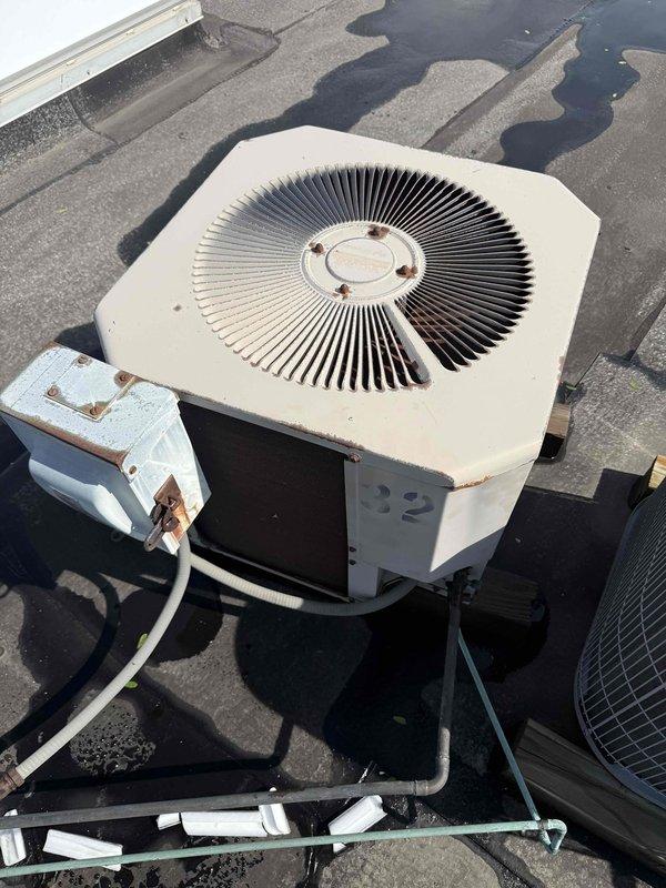 Completed commercial preventive maintenance inspection on rooftop HVAC unit originally installed in 1991. Verified proper operation following recent capacitor replacement, documented equipment condition with photos showing significant age-related deterioration including rust and corrosion on access panels and electrical components, and noted unit may require replacement evaluation in near future.