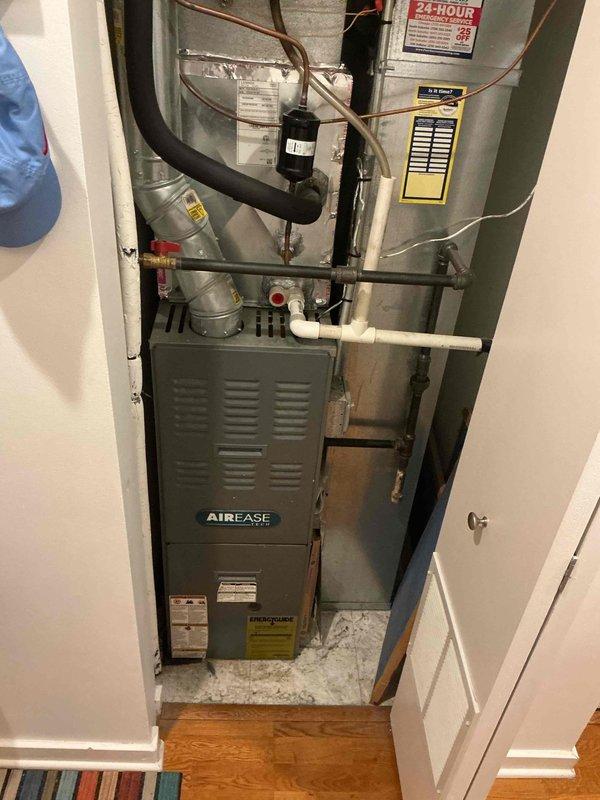 Responded to new customer complaint of HVAC system fan running but no cooling in residential condo unit. Performed diagnostic evaluation of AirEase furnace and cooling system installed in utility closet. Inspected evaporator coil assembly, refrigerant lines, and associated components. Documented system configuration including copper refrigerant lines with insulation, condensate drain lines, and ductwork arrangement. Assessed heat exchanger fins and tubing for proper condition and airflow. Provided customer with findings and repair options for restoring cooling functionality to the system.