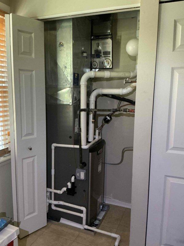 Completed comprehensive clean and check maintenance service on residential air conditioning system. Performed standard diagnostic testing using calibrated instruments to verify system performance and operational parameters, inspected HVAC equipment installation including furnace unit and associated PVC piping network, and documented equipment condition through photographic records. All components found operating within normal specifications with no immediate service concerns identified.