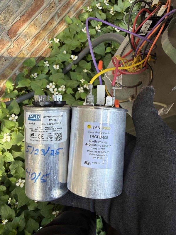 Replaced two failed 40/5 MFD dual-run capacitors on the HVAC system's outdoor condensing unit. One capacitor was covered under warranty from a previous replacement performed last year. Removed the old JARD and TITAN PRO capacitors, transferred all wire connections to the new components, and verified proper terminal connections for compressor and fan motor circuits. System tested and operating within normal parameters upon completion.