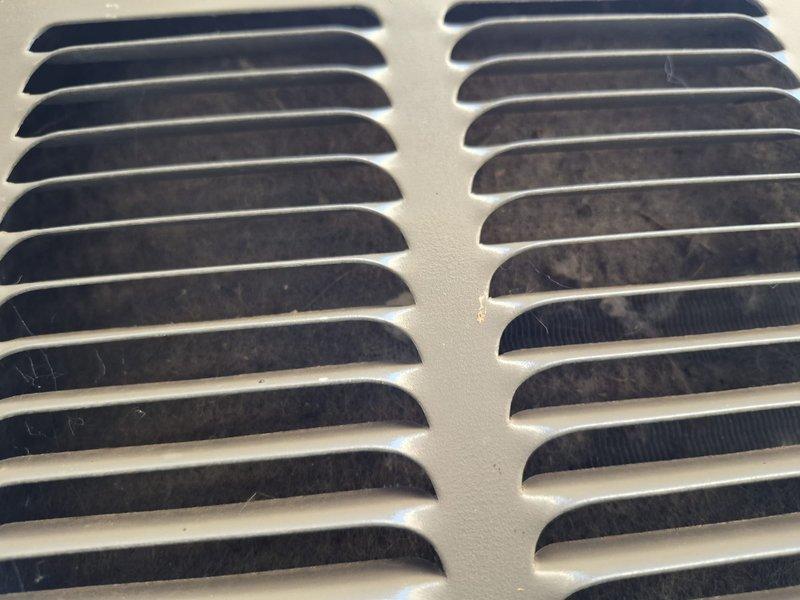 Responded to no cooling call for 10+ year old split system. Upon arrival, performed diagnostic evaluation of both indoor and outdoor units. Inspected air handler ventilation components and condensate drain system. Documented equipment condition with photos showing interior vent grille with accumulated dust and debris, as well as PVC condensate drain line configuration beneath unit. System evaluated for airflow restrictions and proper drainage function. Provided customer with findings and recommended solutions to restore cooling operation.