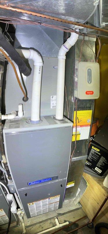 Responded to no cooling complaint on rooftop HVAC unit accessed through neighbor's apartment. Upon arrival, verified thermostat settings, confirmed unit was not producing cold air, and checked system breakers and filter condition. Performed diagnostic evaluation of rooftop condenser unit and indoor air handler system. Documented equipment information and captured photos of both rooftop installation showing dual condenser units with electrical connections and basement air handler with refrigerant lines and ductwork. Completed standard diagnostic protocol and presented repair options to restore cooling operation.