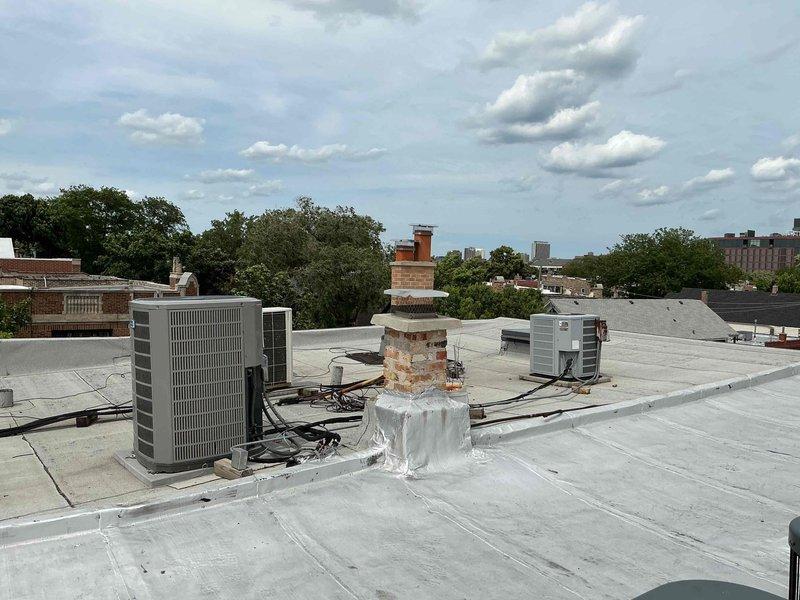 Responded to no cooling complaint on rooftop HVAC unit accessed through neighbor's apartment. Upon arrival, verified thermostat settings, confirmed unit was not producing cold air, and checked system breakers and filter condition. Performed diagnostic evaluation of rooftop condenser unit and indoor air handler system. Documented equipment information and captured photos of both rooftop installation showing dual condenser units with electrical connections and basement air handler with refrigerant lines and ductwork. Completed standard diagnostic protocol and presented repair options to restore cooling operation.