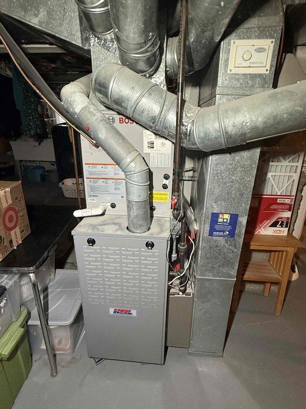 Completed spring preventive maintenance on two-system HVAC installation per Comfort Plan agreement. Performed comprehensive clean and check procedures on both air conditioning units, including inspection of air filter which showed good condition with minimal debris accumulation. Verified proper airflow through ductwork system connected to Heil furnace unit. Documented equipment condition through photographic records showing clean filter media with intact cardboard frame and diamond cross-hatch pattern, along with overall system installation in basement mechanical room. All components operating within normal parameters with no immediate service needs identified.