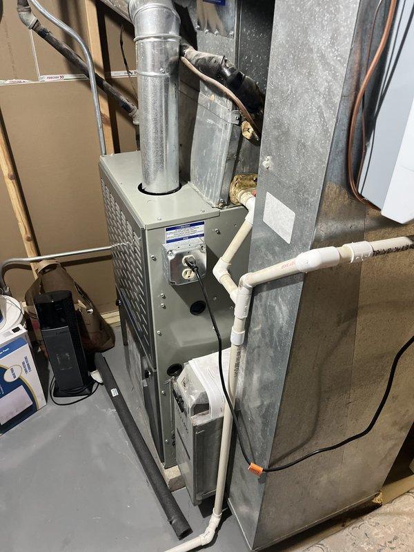 Responded to service call for air conditioning system not cooling efficiently. Performed diagnostic evaluation of existing HVAC system including furnace and air handler unit located in basement utility area. Assessed overall system condition, refrigerant lines, ductwork connections, and equipment configuration. Documented existing equipment information and installation setup including condensate drainage lines and electrical connections for estimate preparation.