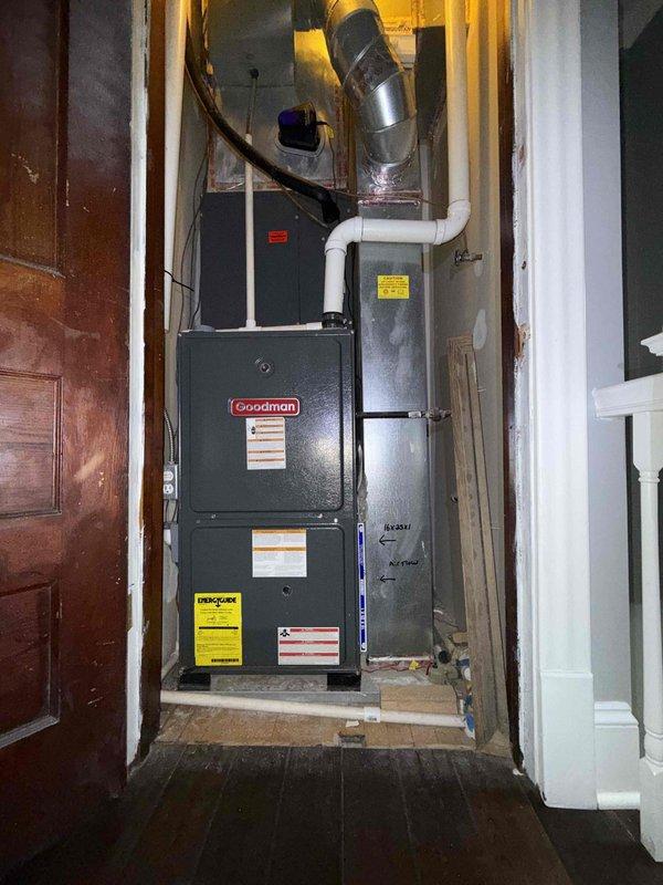 Performed comprehensive clean and check maintenance on second floor Goodman furnace and air conditioning system as part of Silver Comfort Plan service. Inspected blower motor assembly, control board, and electrical connections within furnace compartment, confirming all wiring harnesses and components operating within normal parameters. Documented system condition with interior and exterior photos showing proper installation of furnace unit, PVC condensate piping, and ductwork configuration.