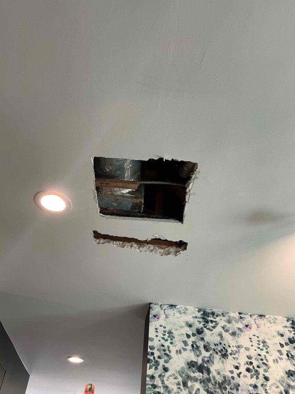 Responded to referral from plumbing contractor regarding water leak traced to HVAC system. Upon arrival, investigated ceiling cavity where moisture damage was evident and found condensate drain line from Carrier air handler was leaking, causing water intrusion into living space. Cut access panels in ceiling to locate source of leak and assess extent of damage to ductwork and framing. Inspected outdoor Carrier condensing unit and verified system operation. Identified clogged condensate drain line as root cause of overflow condition. Cleared blockage from drain line, tested drainage flow, and confirmed proper operation of condensate removal system. Photographed damaged areas and HVAC equipment for documentation purposes.