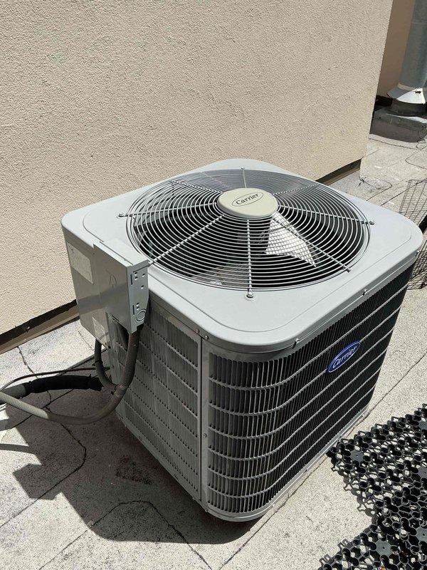 Responded to referral from plumbing contractor regarding water leak traced to HVAC system. Upon arrival, investigated ceiling cavity where moisture damage was evident and found condensate drain line from Carrier air handler was leaking, causing water intrusion into living space. Cut access panels in ceiling to locate source of leak and assess extent of damage to ductwork and framing. Inspected outdoor Carrier condensing unit and verified system operation. Identified clogged condensate drain line as root cause of overflow condition. Cleared blockage from drain line, tested drainage flow, and confirmed proper operation of condensate removal system. Photographed damaged areas and HVAC equipment for documentation purposes.