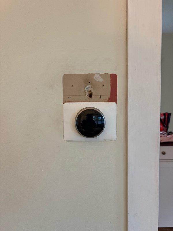 Installed new thermostat wiring and mounted thermostat unit on existing wall location. Connected multi-conductor thermostat cable to terminal block, including Y1, Y2, G, O/B, Rc, Rh, W1, W2, and C terminals with appropriate color-coded wires for proper HVAC system communication and control.