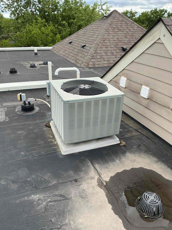 Performed AC coil cleaning service on rooftop-mounted condenser unit at multi-unit residential property. Thoroughly cleaned evaporator and condenser coils to restore optimal heat transfer efficiency and system performance. Unit documented with photographic records showing completion of work on flat membrane roof with proper drainage considerations noted.