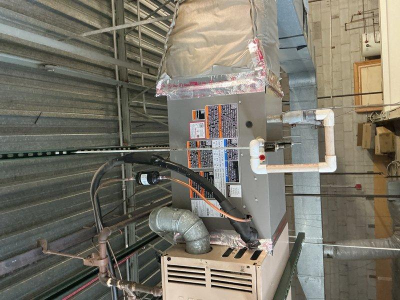 Completed commercial HVAC system replacement including air conditioning unit and evaporator coil installation in mechanical room. New equipment was properly positioned, secured, and connected with insulated ductwork, electrical conduit, and refrigerant lines. System was tested and confirmed operational upon completion.
